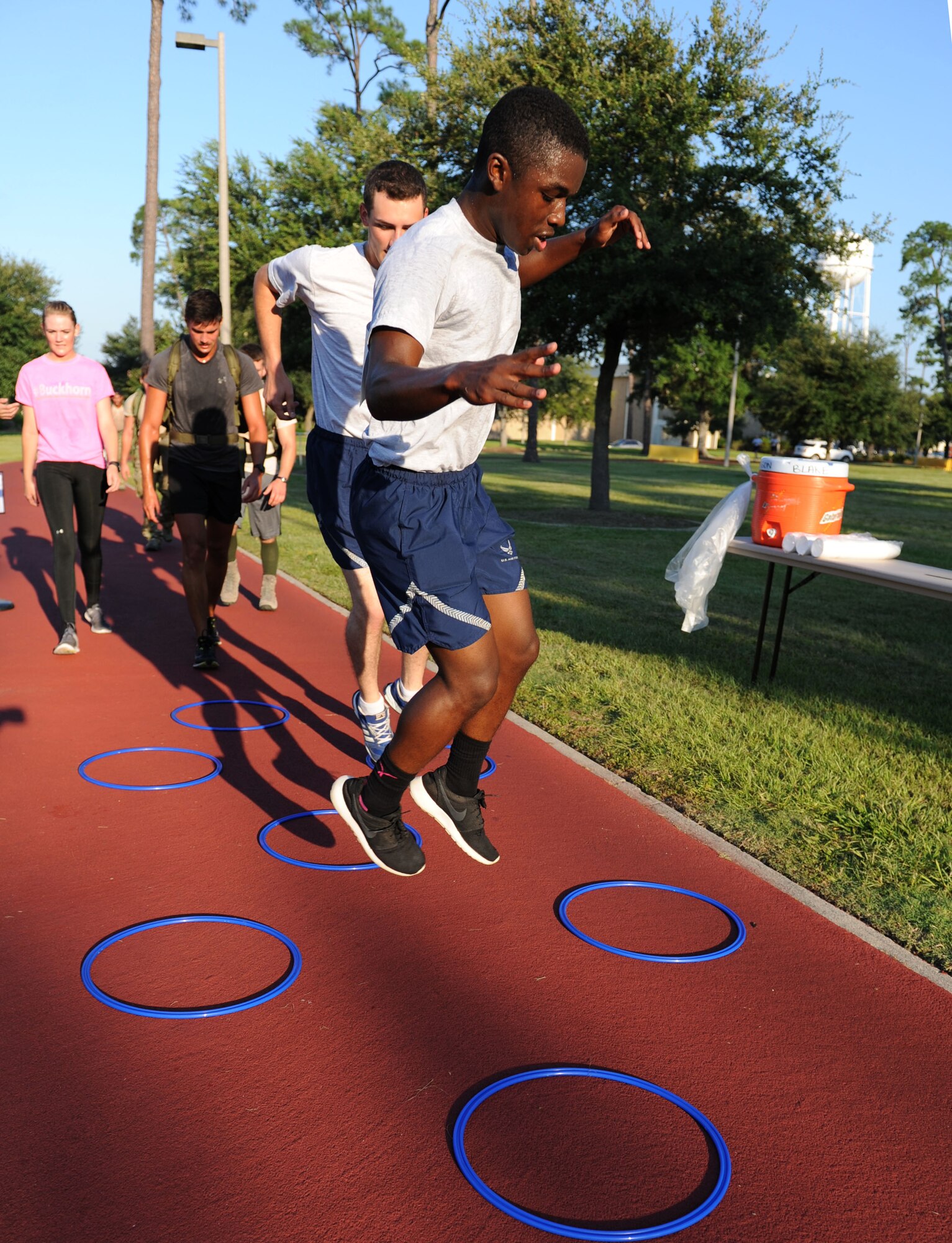 Airmen Basic Detavious Bonner and Chase Stimpel, 334th Training Squadron students, maneuver through a 12-foot agility ring course during the Gauntlet 5K & Obstacle Course event Aug. 28, 2015, at the Crotwell Track, Keesler Air Force Base, Miss. The 81st Force Support Squadron-sponsored event involved participants completing a 5K run then making their way through nine different obstacles. (U.S. Air Force photo by Kemberly Groue)