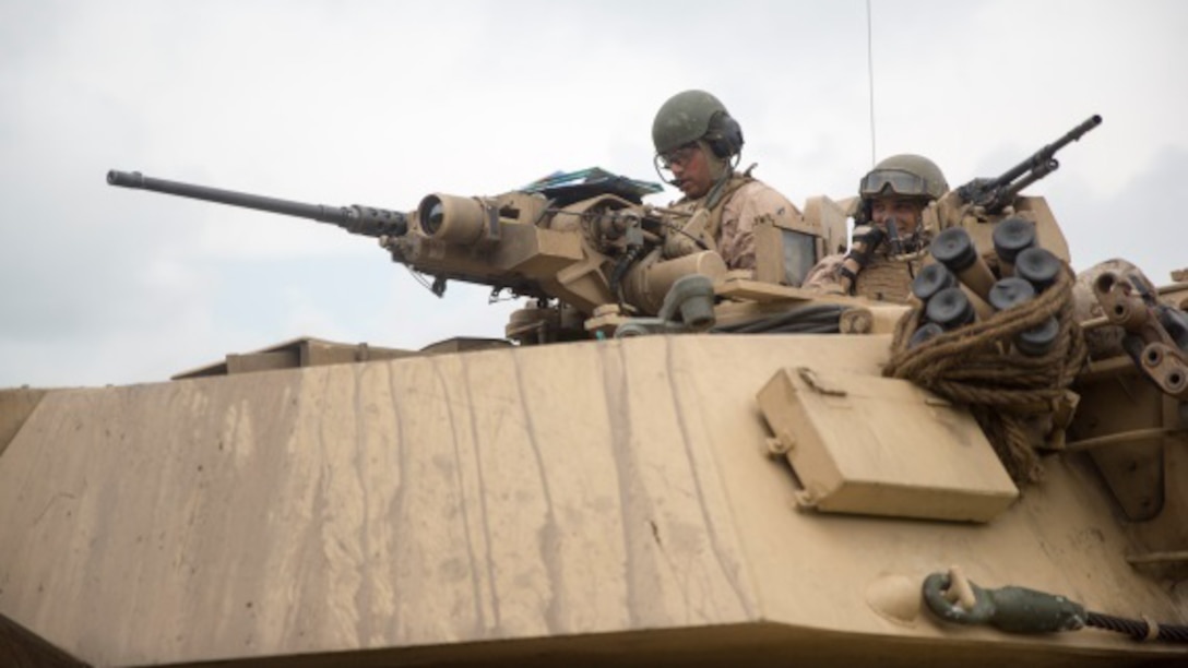 Two Marines from Bravo Company, 2nd Tank Battalion, call in a situation report on their M1A1 Abrams main battle tank during an offensive and defensive maneuver exercise at Marine Corps Base Camp Lejeune, N.C., Aug. 26, 2015. Each platoon from the company consolidated and received a debrief after they completed their maneuvers, learning what they did well and what to improve on. 