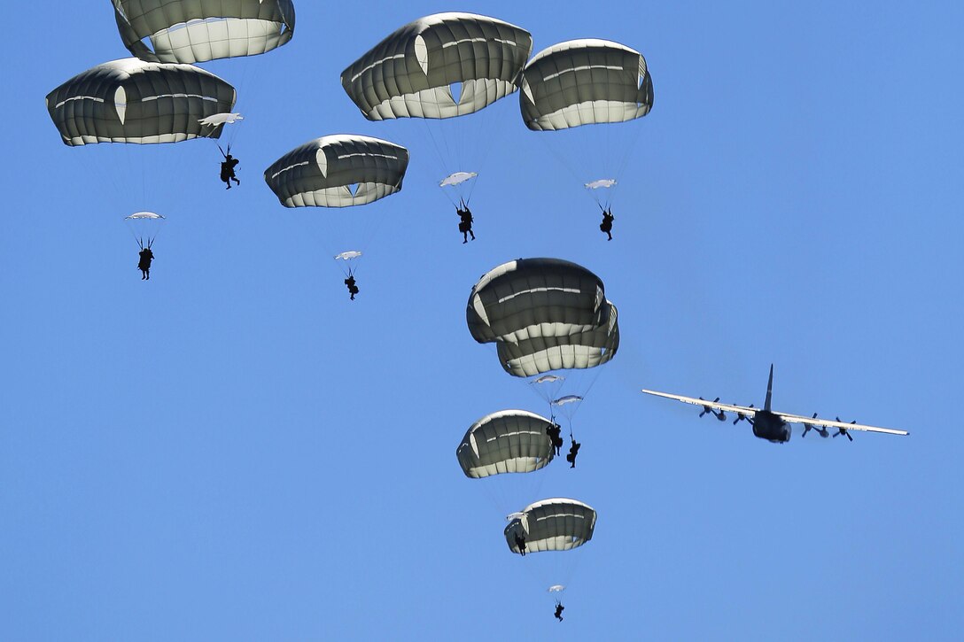 U.S. paratroopers descend after jumping from a C-130 Hercules over a drop zone on Joint Base Elmendorf-Richardson, Alaska, Aug. 24, 2015. U.S. and Japanese paratroopers used U.S. and Australian aircraft during the practice jump as part of Pacific Airlift Rally 2015, a biennial tactical exercise. The U.S. paratroopers are assigned to 1st Battalion , 501st Infantry Regiment, and the Hercules is assigned to the 374th Wing from Yokota Air Base, Japan. U.S. Air Force photo by Alejandro Pena