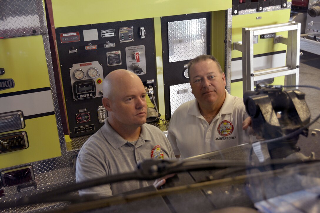 U.S. Air Force Staff Sgt. Jeret Kinnaird, firefighter for the North Carolina Air National Guard, 145th Civil Engineer Squadron, and his supervisor, Master Sgt. Donald D. Willis, Jr., Assistant Chief of Operations for the NCANG, inspects the nozzle on a P-19 Stryker Air Firefighting Rescue truck, making sure the gallons per minute is placed on the correct setting, at Fire Station 41, Charlotte Douglas International Airport, Aug. 4, 2015. Kinnaird was recognized as Military Fire Fighter of the Year and presented "The Chief Albert Fitzpatrick Award." July, 22, 2015.  (U.S. Air National Guard photo by Master Sgt. Patricia F. Moran, 145th Public Affairs/Released)