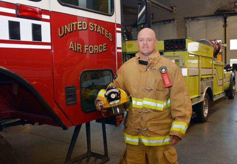 U.S. Air Force Staff Sgt. Jeret Kinnaird, firefighter for the North Carolina Air National Guard, 145th Civil Engineer Squadron, stands in front of an airport Rescue Firefighting truck after being interviewed, Aug. 4, 2015, at Fire Station 41, Charlotte Douglas International Airport. On July, 22, 2015, Kinnaird was recognized as Military Fire Fighter of the Year and presented "The Chief Albert Fitzpatrick Award." (U.S. Air National Guard photo by Master Sgt. Patricia F. Moran, 145th Public Affairs/Released)