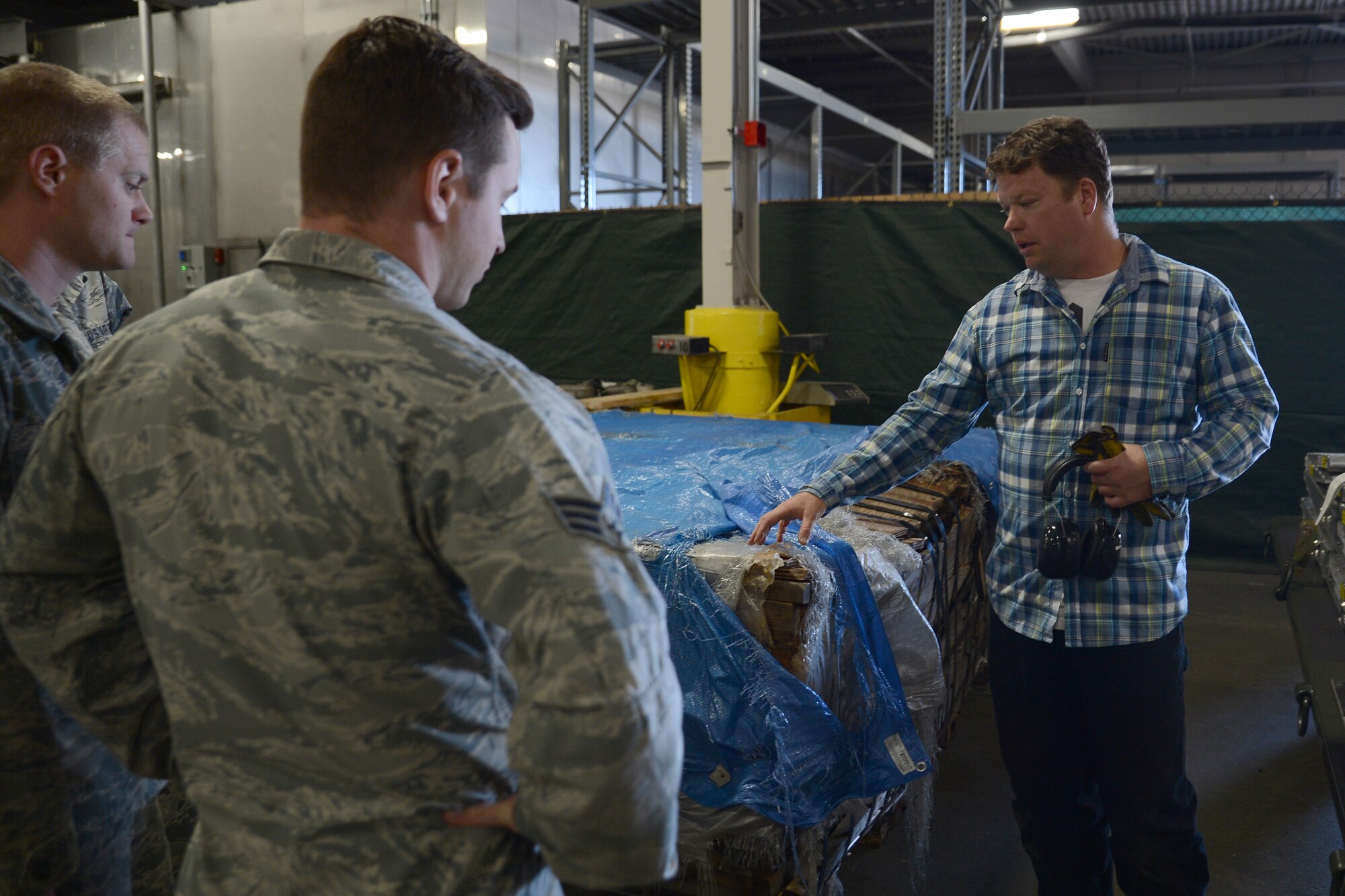 Jason Aven (right), 62nd Aerial Port Squadron freight load leader, talks about a pallet July 30, 2015, at Joint Base Lewis-McChord, Wash. The 62nd APS has created a more proficient method of building combat pallets which will save the Air Force more than $4,4000 and 19 man hours per pallet. (U.S. Air Force photo/Airman 1st Class Keoni Chavarria)