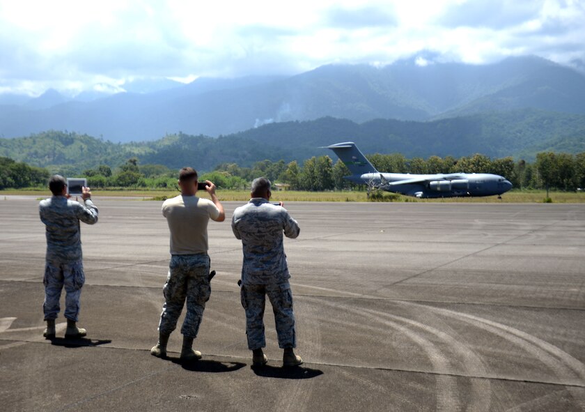 New Horizons Honduras 2015 training exercise personnel photograph a C-17 Globemaster III from the 62nd Airlift Wing out of Joint Base Lewis-McChord, Wash., as it arrives at Base Aerea Coronel Hector Caraccioli Moncada in La Ceiba, Honduras, Aug. 28, 2015. The C-17 transported New Horizons vehicles, equipment and personnel to Hurlburt Field, Fla., while all remaining equipment will be transported via sealift. New Horizons was launched in the 1980s and is an annual joint humanitarian assistance exercise that U.S. Southern Command conducts with a partner nation in Central America, South America or the Caribbean. The exercise improves joint training readiness of U.S. and partner nation civil engineers, medical professionals and support personnel through humanitarian assistance activities. (U.S. Air Force photo by Capt. David J. Murphy/Released)
