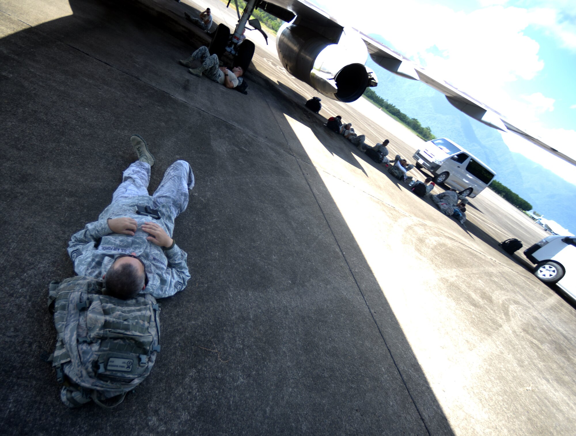 New Horizons Honduras 2015 training exercise personnel wait in the shade of an aircraft for their flight back to the United States from Base Aerea Coronel Hector Caraccioli Moncada in La Ceiba, Honduras, Aug. 28, 2015. Vehicles, equipment and personnel that were part of the New Horizons exercise redeployed to Hurlburt Field, Fla., while all remaining equipment will return via sealift. New Horizons was launched in the 1980s and is an annual joint humanitarian assistance exercise that U.S. Southern Command conducts with a partner nation in Central America, South America or the Caribbean. The exercise improves joint training readiness of U.S. and partner nation civil engineers, medical professionals and support personnel through humanitarian assistance activities. (U.S. Air Force photo by Capt. David J. Murphy/Released)