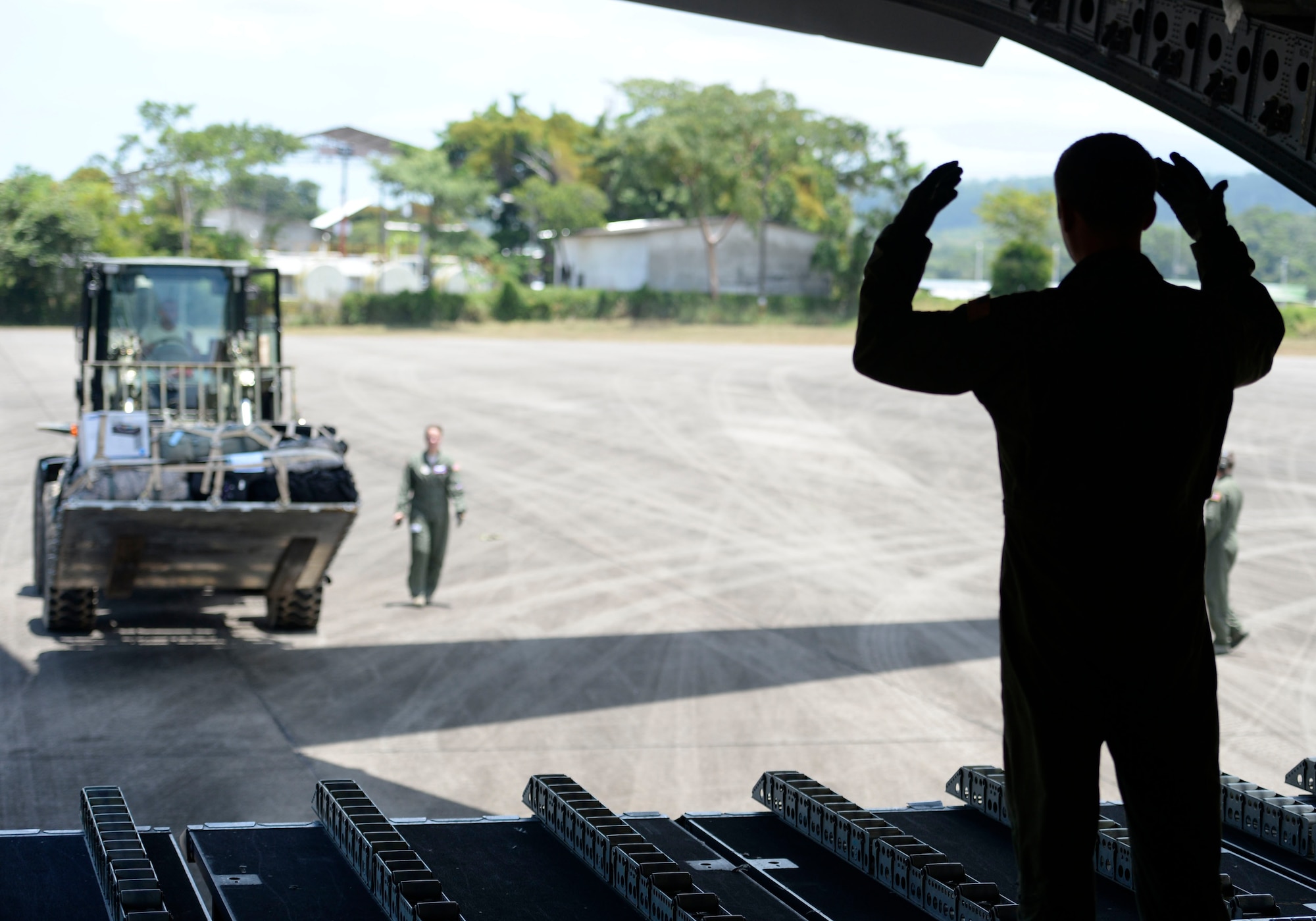 A loadmaster with the 62nd Airlift Wing out of Joint Base Lewis-McChord, Wash., guides U.S. Air Force Staff Sgt. Raul Perez, 823rd Expeditionary RED HORSE Squadron vehicle maintenance NCOIC, out of Hurlburt Field, Fla., as he moves a pallet with a forklift onto a waiting C-17 Globemaster III from the 62nd AW at Base Aerea Coronel Hector Caraccioli Moncada in La Ceiba, Honduras, Aug. 28, 2015. Vehicles, equipment and personnel from the New Horizons Honduras 2015 training exercise redeployed to Hurlburt Field and all remaining equipment will be moved via sealift. New Horizons was launched in the 1980s and is an annual joint humanitarian assistance exercise that U.S. Southern Command conducts with a partner nation in Central America, South America or the Caribbean. The exercise improves joint training readiness of U.S. and partner nation civil engineers, medical professionals and support personnel through humanitarian assistance activities. (U.S. Air Force photo by Capt. David J. Murphy/Released)