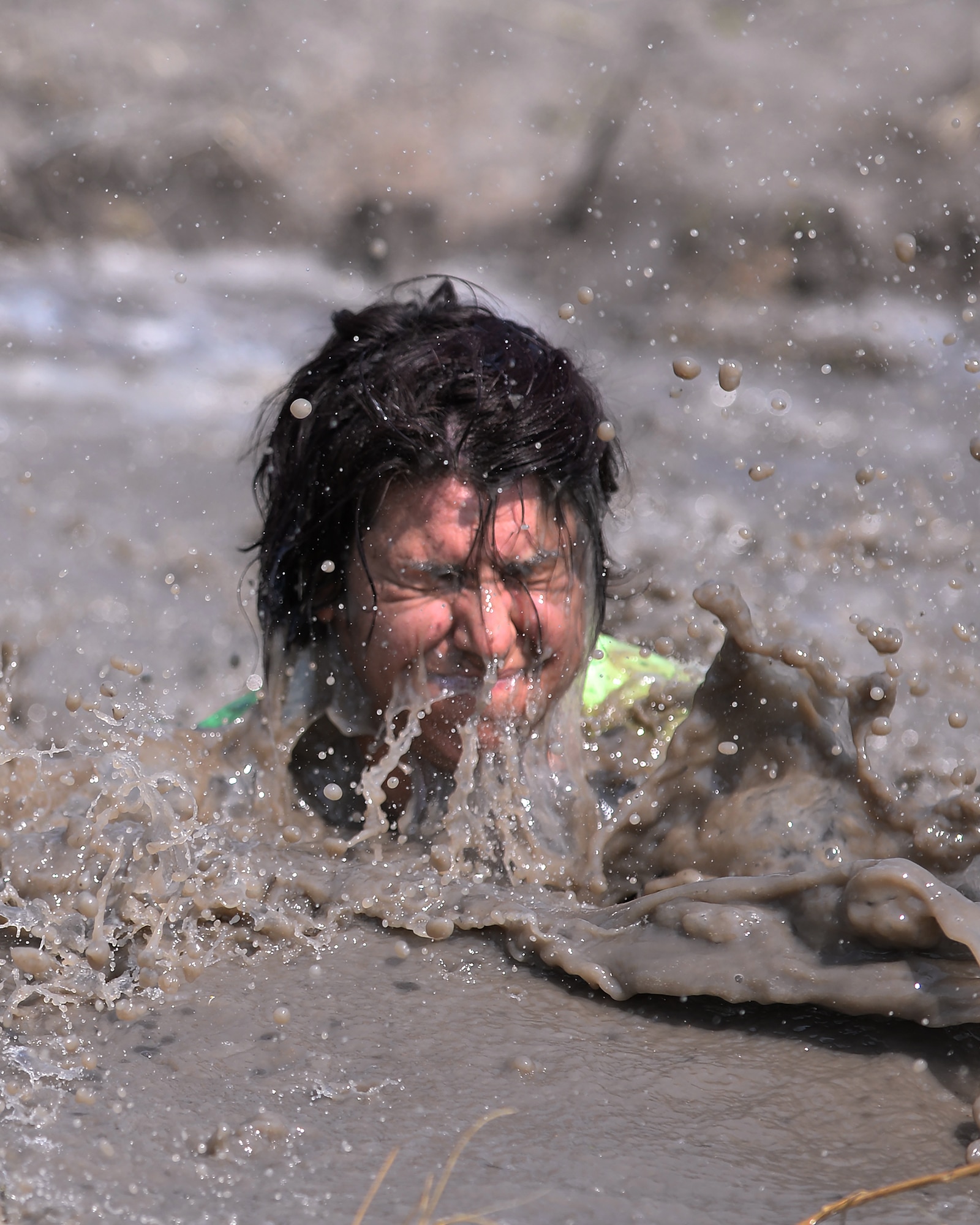 Jill Randall, 90th Missile Wing Sexual Assault Response coordinator, emerges from muddy water Aug. 29, 2015, after falling during one of the obstacles of the second annual F.E. Warren Air Force Base, Wyo., mud run. Most of the five-kilometer course was located on the 90th Civil Engineer Squadron’s training yard. (U.S. Air Force photo by Airman 1st Class Brandon Valle)
