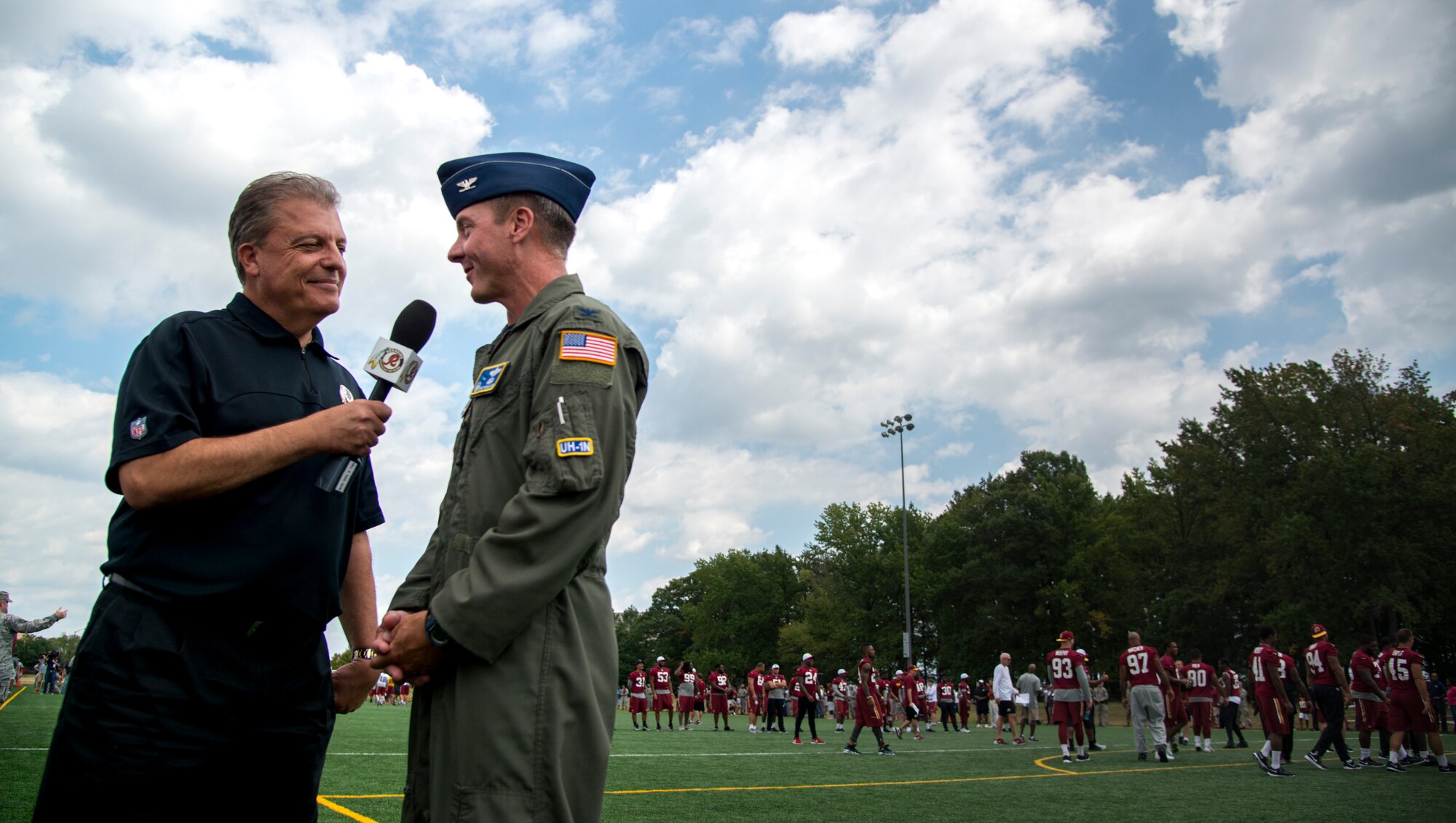 Larry Michael, Redskins Nation host, interviews Col. Bradley Hoagland, 11th Wing/JBA commander, during a Washington Redskins walkthrough practice at the West Fitness Center’s field, Joint Base Andrews, Md., Aug. 28, 2015. The Redskins practice was followed by an autograph session with fans as part of their Redskins Salute effort. (U.S. Air Force photo by Airman 1st Class Philip Bryant/Released)