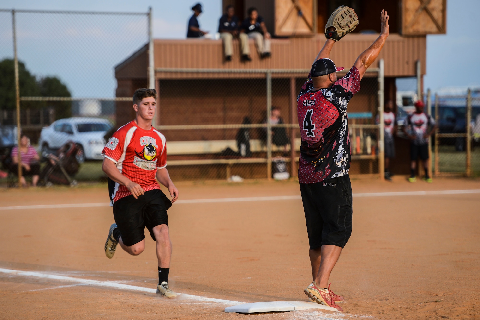 U.S. Air Force Airman 1st Class Matthew Stiltner, 633rd Civil Engineer Squadron team member, runs to first base as Staff Sgt. Alan Shea, 45th Intelligence Squadron team member, shouts for the ball during the 2015 Intramural Softball Championship at Langley Air Force Base, Va., Aug. 25, 2015. The 45th IS prevailed as the victors, defeating the 633rd CES eight runs to seven. (U.S. Air Force photo by Senior Airman Kayla Newman/Released)