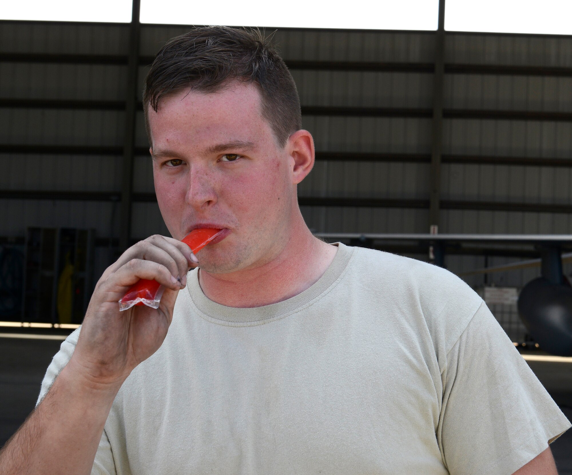 U.S. Air Force Senior Airman Stephen Baber, 20th Aircraft Maintenance Squadron aircraft electrical and environmental systems specialist, eats an ice pop provided by Shaw Top 3 members during a mentorship event at Shaw Air Force Base, S.C., Aug. 28, 2015.  The event gave Airmen the opportunity to talk about any problems they may be facing inside and outside the workplace with senior NCOs. (U.S. Air Force photo by Airman 1st Class Christopher Maldonado/Released)