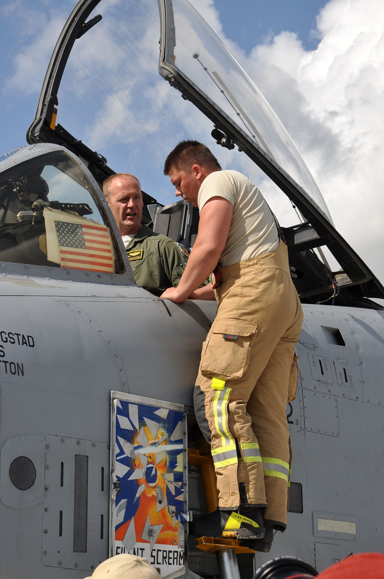 Maj. Rick Mitchell, a 303d Fighter Squadron A-10 Thunderbolt II pilot with the 442d Fighter Wing out of Whiteman Air Force Base, Mo., shows a Latvian firefighter some safety features on the A-10 Aug. 26 at Leilvarde Air Base in Latvia.  Mitchell was the first U.S. fighter pilot to land a fighter jet at the airfield.  The mission is part of Operation Atlantic Resolve where U.S. forces are partnering with European allies to strengthen their relationship to face potential future challenges. Latvians are learning the safety features of the A-10, how to refuel and how to handle emergencies.  The 442d Fighter Wing will be part of the exercise for approximately three weeks. (U.S. Air Force photo by Capt. Denise Haeussler)