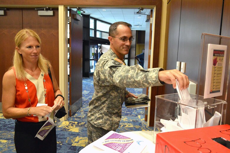 Col. Brett Funck, Fort Bragg Garrison commander, and his wife, Sheelagh, cast their votes during an observance for Women’s Equality Day Aug. 26, 2015, held at the Catering and Conference Center, Fort Bragg, North Carolina. (U.S. Air Force photo/Marvin Krause)