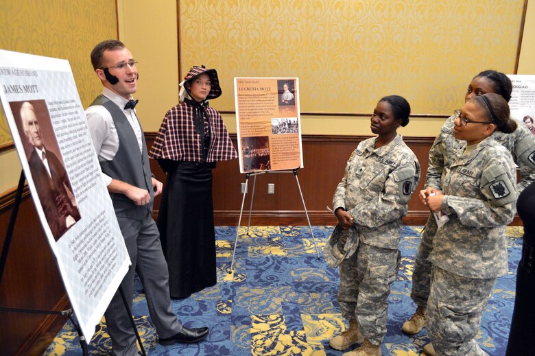 Air Force Senior Airman Aaron Gregory, 43rd Comptroller Flight, dressed as James Mott, role-plays with Women’s Equality Day observance attendees, answering questions and explaining what they accomplished for women’s equality Aug. 26, 2015, at the Catering and Conference Center Fort Bragg, North Carolina. Air Force Staff Sgt. Amanda Alvarez, 43rd Comptroller Flight, dressed as Lucretia Mott, looks on. Women’s Equality Day is a symbol of women’s continued fight for equal rights and that the United States commends and supports them. Today, it is celebrated in honor of modern day women's rights to be seen as equals to men. (U.S. Air Force photo/Marvin Krause)