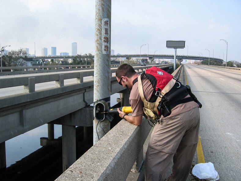 A special tactics troop from the Kentucky Air National Guard cuts down street light poles along Interstate 610 in New Orleans following Hurricane Katrina Sept. 3, 2005, to clear the way for a helicopter landing zone. (U.S. Air National Guard photo)