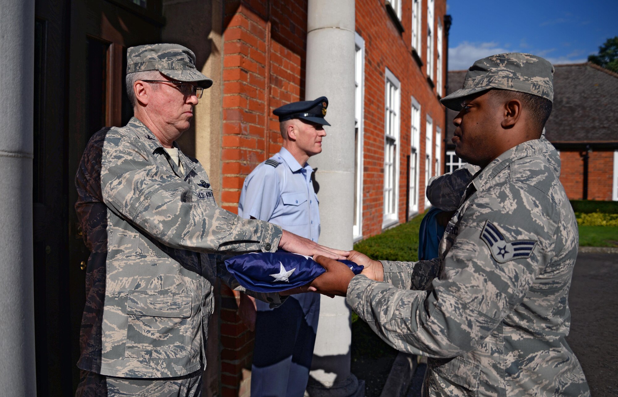 U.S. Air Force Col. Matthew Powell, left, 352nd Special Operations Wing vice commander, receives the U.S. flag from a flag detail after a retreat ceremony, Aug. 28, 2015, on RAF Mildenhall, England. This month’s retreat is to celebrate 2015’s Year of the Air Commando, marking the 25th anniversary of the activation of Air Force Special Operations Component and 35th anniversary of Operation EAGLE CLAW; the failed Iranian hostage rescue crisis. (U.S. Air Force photo by Senior Airman Christine Halan/Released)