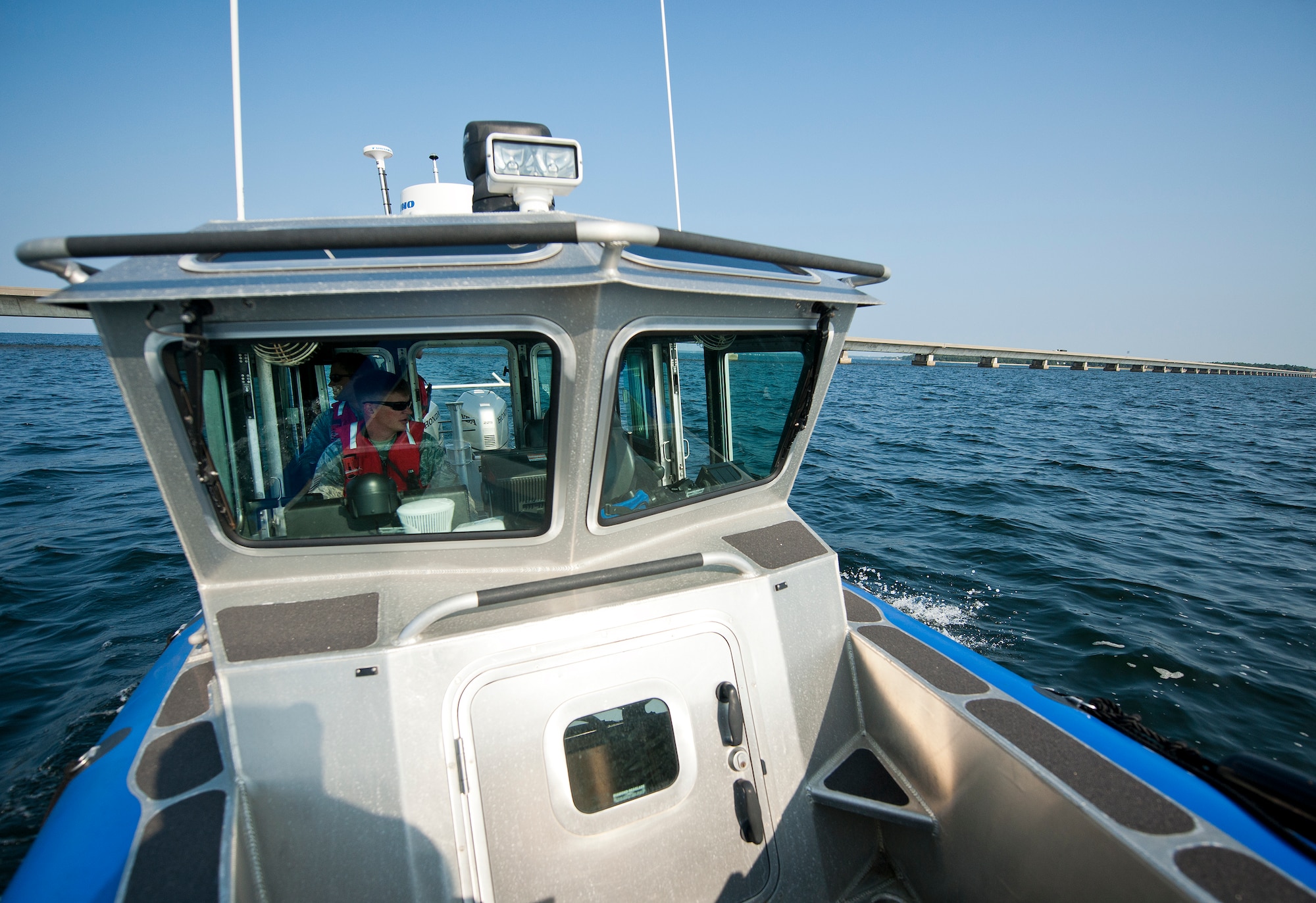 Tech. Sgt. Brent Young, 96th Security Forces Squadron, takes the squadron’s boat past the Mid-Bay Bridge during a patrol around the base’s shoreline Aug. 25 at Eglin Air Force Base, Fla.  Recently, a group of defenders became qualified to operate the boat through Coast Guard certification.  They are responsible for monitoring and security of Eglin’s 153 miles of coastline.  (U.S. Air Force photo/Samuel King Jr.)