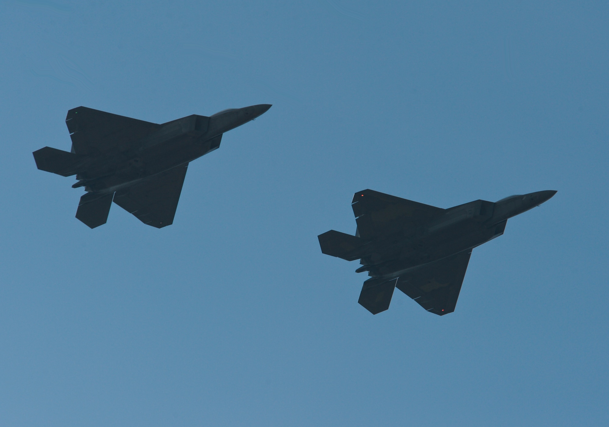 Two U.S. Air Force F-22 Raptors fly over the flightline at Lask Air Base, Poland, Aug. 31, 2015. The aircraft are part of the inaugural F-22 training deployment to Europe and are funded by the European Reassurance Initiative, which is intended to increase the capability, readiness and responsiveness of NATO forces in part by funding rotational force presence in Eastern Europe. The U.S. Air Force routinely deploys aircraft and Airmen to Europe for training and exercises.  (U.S. Air Force photo by Staff Sgt. Joe W. McFadden/Released)