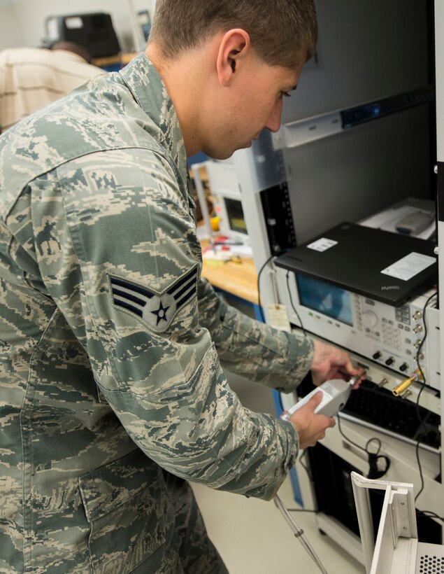 U.S. Air Force Senior Airman Samuel Weirick, 1st Maintenance Squadron precision measurement equipment laboratory journeyman, calibrates a signal generator at Langley Air Force Base, Va., Aug. 18, 2015. The PMEL specialists are responsible for calibrating equipment used for measuring in practically every aspect of maintenance. (U.S. Air Force photo by Senior Airman Kayla Newman/Released)