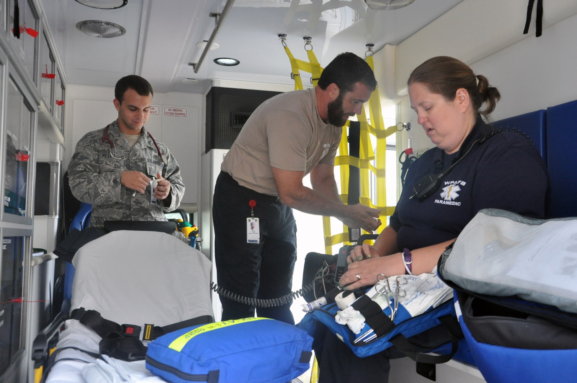 Wright Patterson AFB Medical Center Paramedics Senior Airman Jacob Miller, Kevin Bull, and Amy Wilt inspect equipment and supplies on one of the medical center’s five ambulances to ensure they are ready to respond to emergencies anywhere on base. Air Force photo by Bryan Ripple.