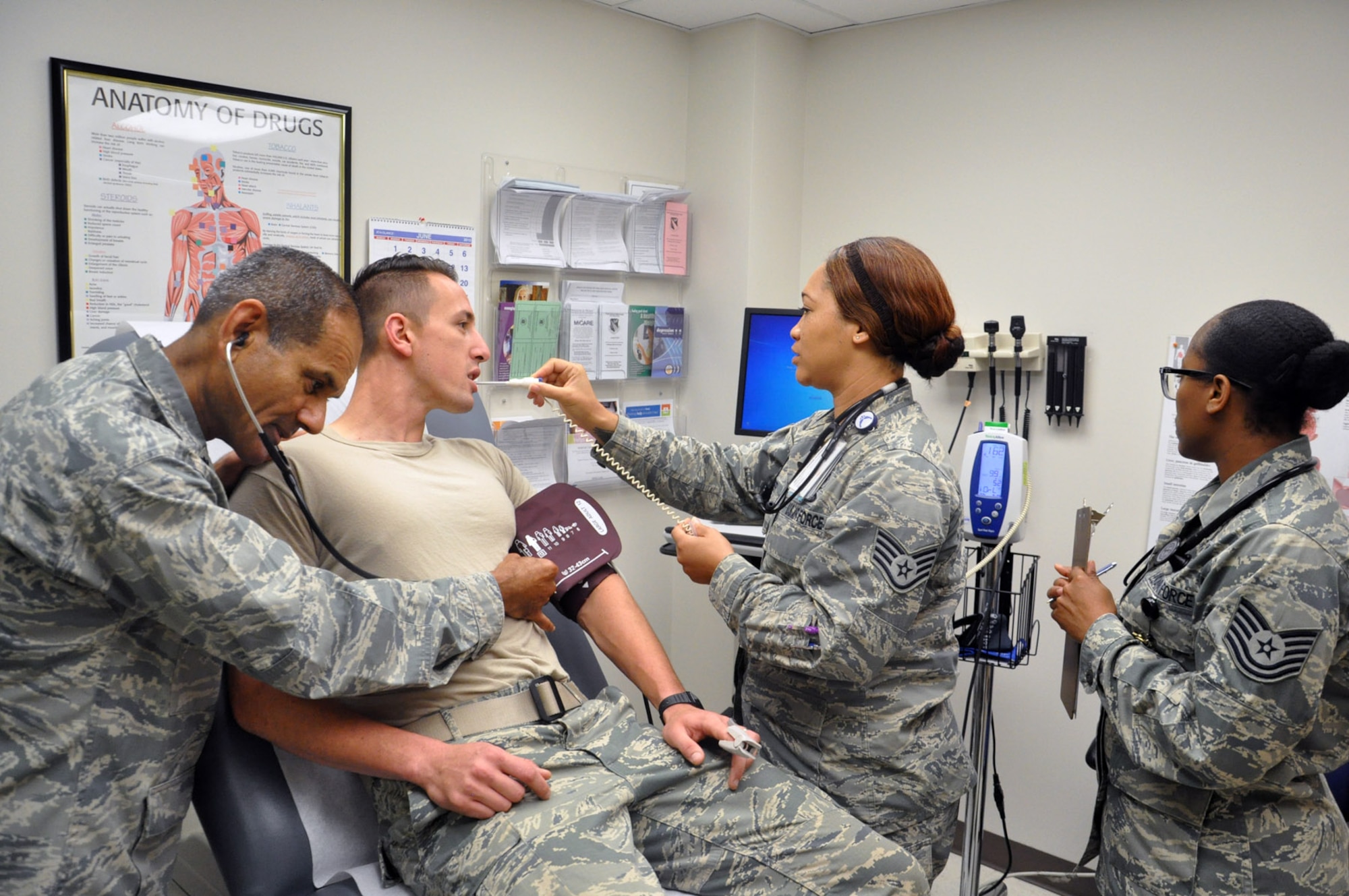 Senior Airman Michael Lizzi, a medical technician with the Family Health Flight, undergoes a portion of his annual Physical Health Assessment (PHA) August 20. Performing the assessment are Dr. (Lt. Col). Reynold D’Lima, Physician Element Chief; Staff Sgt. Tinesha Oliver, Family Health Clinic Supervisor; and Tech. Sgt. Susan Rhodes, NCOIC, Family Health Red Element. Air Force photo by Bryan Ripple.