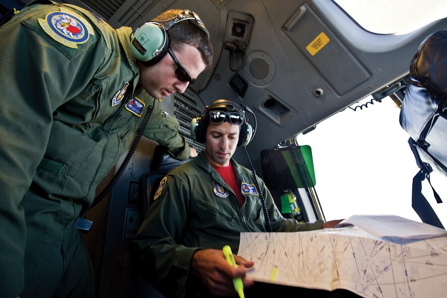 Capt. Robert Deland (left) and Maj. Hesham Aly discuss the flight plan inside a C-17 Globemaster III July 31. Both Airmen serve as Citizen Airmen with the 732nd Airlift Squadron. (U.S. Air Force photo by Christian De Luca)