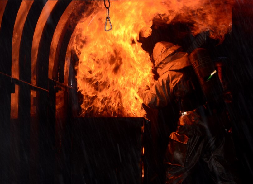 Staff Sgt. Michael White, 51st Civil Engineer Squadron crew chief, stands amid the flames of a training fire Aug 26, 2015, at Osan Air Base, Republic of Korea. White was training members of the Songtan fire station on proper aircraft fire extinguishing techniques and procedures. (U. S. Air Force photo by Staff Sgt. Benjamin Sutton) 