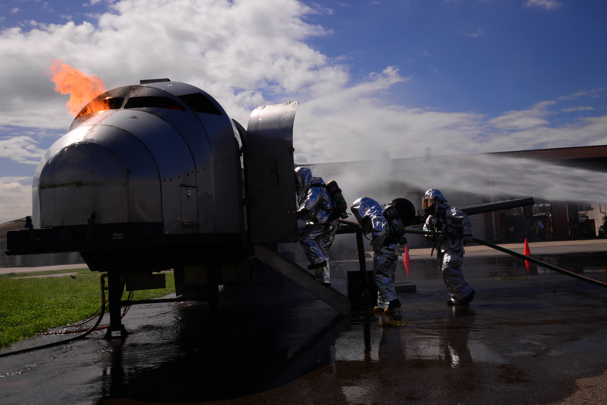 Two firefighters from the Songtan fire station followed by Staff Sgt. Michael White, 51st Civil Engineer Squadron crew chief, enter a training aircraft to perform a fire extinguishing exercise Aug 26, 2015, at Osan Air Base, Republic of Korea. Firefighters from the 51st CES recently hosted a fire-training event and invited the local firefighters as well as firefighters from the Republic of Korea air force to participate. (U. S. Air Force photo by Staff Sgt. Benjamin Sutton) 