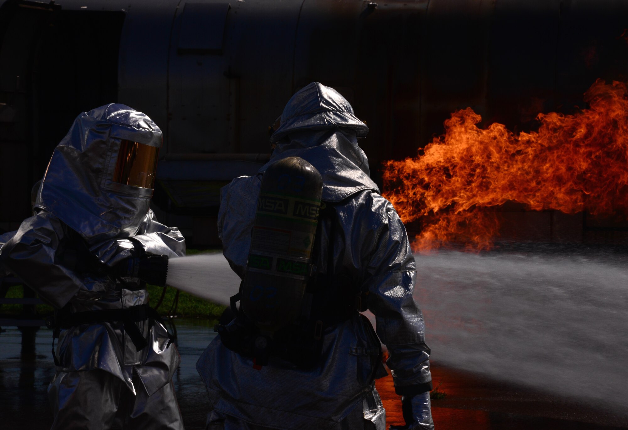 Firefighters from the Songtan fire station perform fire-sweeping maneuvers during a training event Aug 26, 2015, at Osan Air Base, Republic of Korea. After the initial fire is out, the firefighters continue to spray the burn site until all the hot spots were gone and all the flames were out. This process, known as overhaul, is used to ensure the fire won’t start back up. (U. S. Air Force photo by Staff Sgt. Benjamin Sutton) 