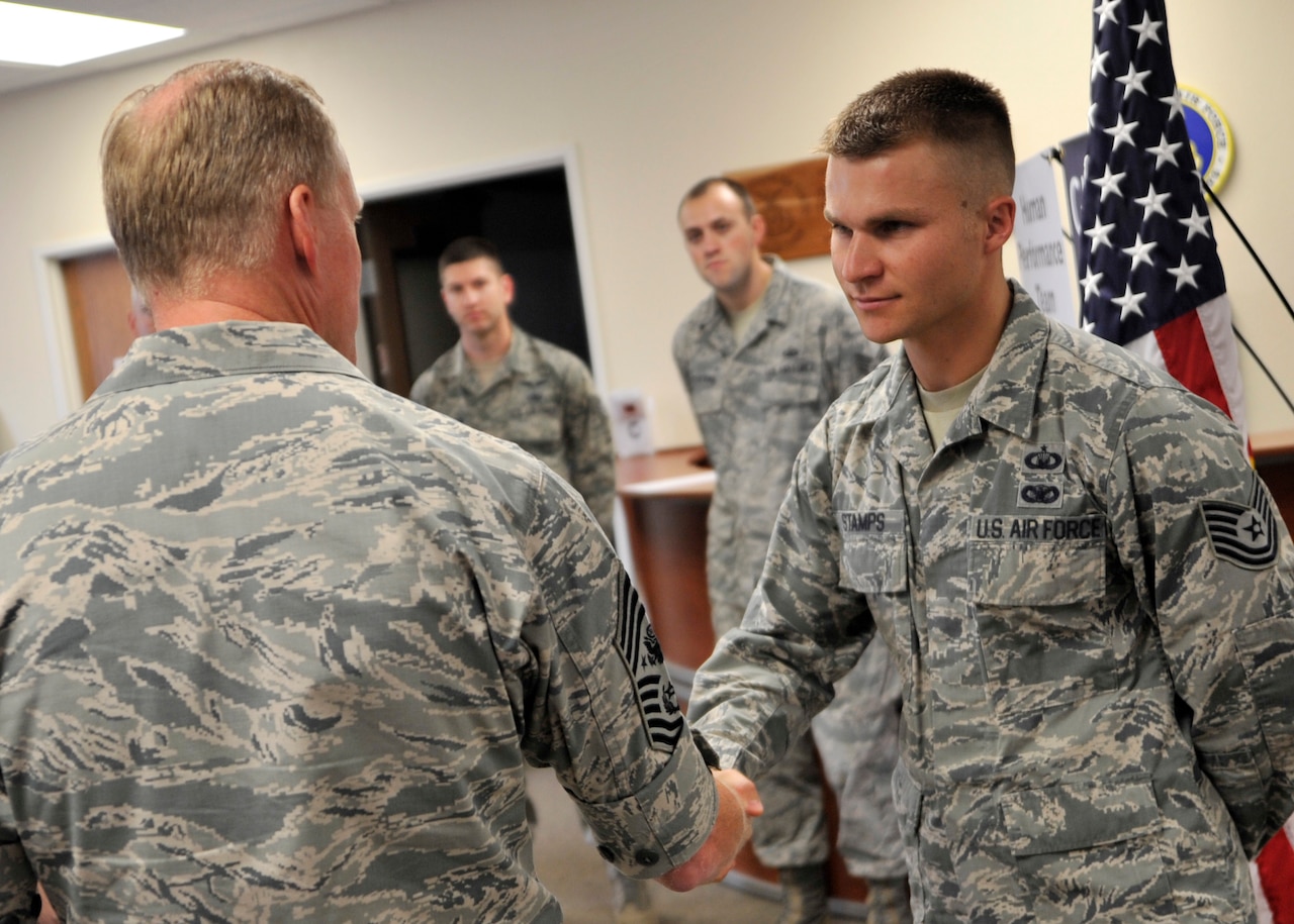Tech Sgt. Noah Stamps, 432nd Wing/432nd air Expeditionary Wing command chief executive assistant, is coined by Chief Master Sergeant of the Air Force James A. Cody for superior performance during his reenlistment ceremony at Creech Air Force Base, Nevada, July 15, 2014. During his 13 year career, Stamps has served in 4 different Air Force Specialty Codes. (Courtesy Photo) 
