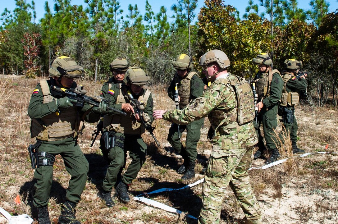 A U.S. Army Green Beret, center foreground, instructs members of the Colombian Compañía Jungla Antinarcóticos during “Glass House Drills” meant to simulate clearing the interior of a building part of a joint training exercise on Eglin Air Force Base, Fla., Nov. 20, 2015. The Green Beret is assigned to the 7th Special Forces Group. U.S. Army photo by Maj. Thomas Cieslak