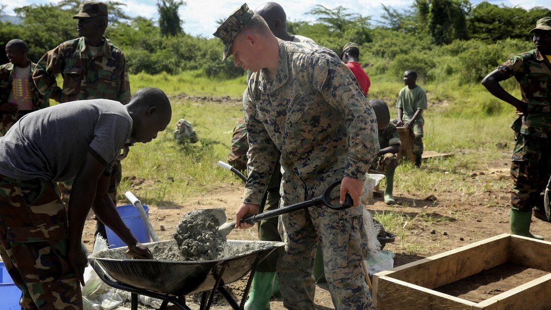 U.S. Marine Sgt. Alfred Darsey, a combat engineer with Special-Purpose Marine Air-Ground Task Force Crisis Response-Africa, helps a Uganda People’s Defense Force soldier mix concrete during a civil engineering exercise at Camp Singo, Nov. 16, 2015. The exercise helps the partner nations fortify their civil engineering skills while strengthening the bond between the two.