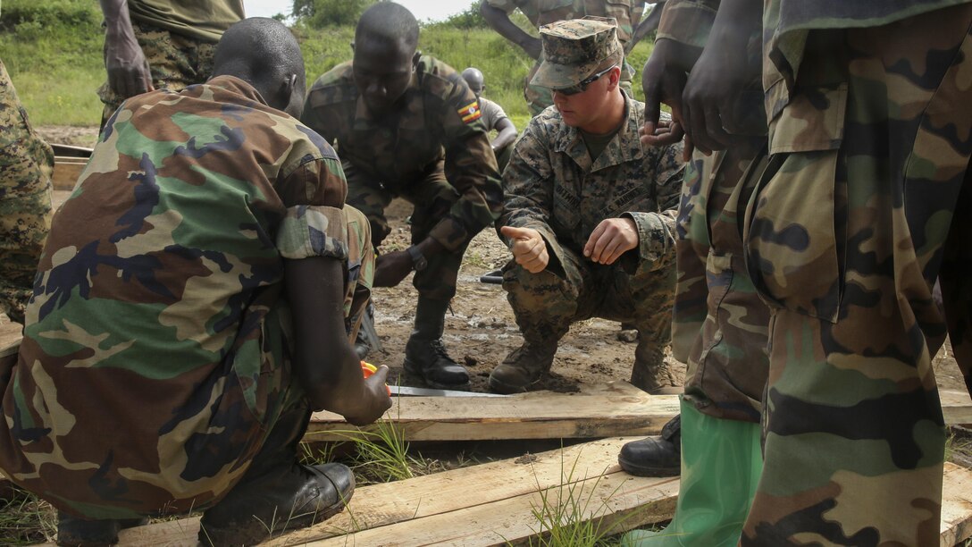 U.S. Marine Cpl. Brandon Ditmire, a combat engineer with Special-Purpose Marine Air-Ground Task Force Crisis Response-Africa, gives a thumbs-up to a Uganda People’s Defense Force soldier during a civil engineering exercise at Camp Singo, Nov. 16, 2015. The exercise helps the partner nations fortify their civil engineering skills while strengthening the bond between the two.