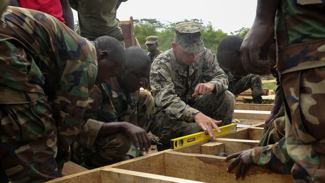 U.S. Marine Sgt. Alfred Darsey, a combat engineer with Special-Purpose Marine Air-Ground Task Force Crisis Response-Africa, helps Uganda People’s Defense Force soldiers level their structure during a civil engineering exercise at Camp Singo, Nov. 16, 2015. The exercise helps the partner nations fortify their civil engineering skills while strengthening the bond between the two.