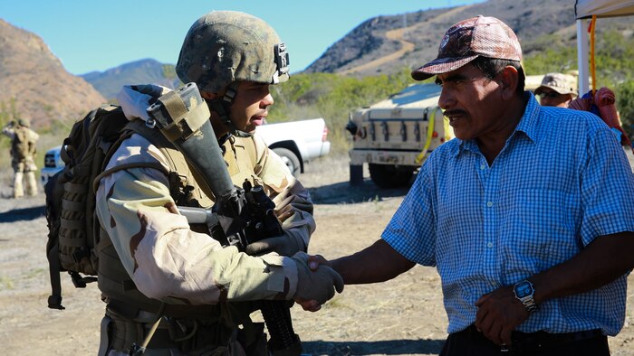 A Marine with 1st Law Enforcement Battalion, I Marine Expeditionary Force Headquarters Group, I MEF practices his community engagement with a role-player during mobile immersion training at Marine Corps Base Camp Pendleton, Calif., Nov. 20, 2015. Mobile immersion training is a scenario-based training exercise in which the Marines engage in locating, apprehending and transporting a high-value individual.