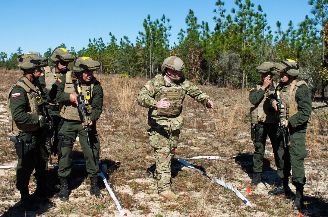A U.S. Army Green Beret, center, instructs members of the Colombian Compañía Jungla Antinarcóticos during “Glass House Drills” meant to simulate clearing the interior of a building part of a joint training exercise on Eglin Air Force Base, Fla., Nov. 20, 2015. U.S. Army photo by Maj. Thomas Cieslak
