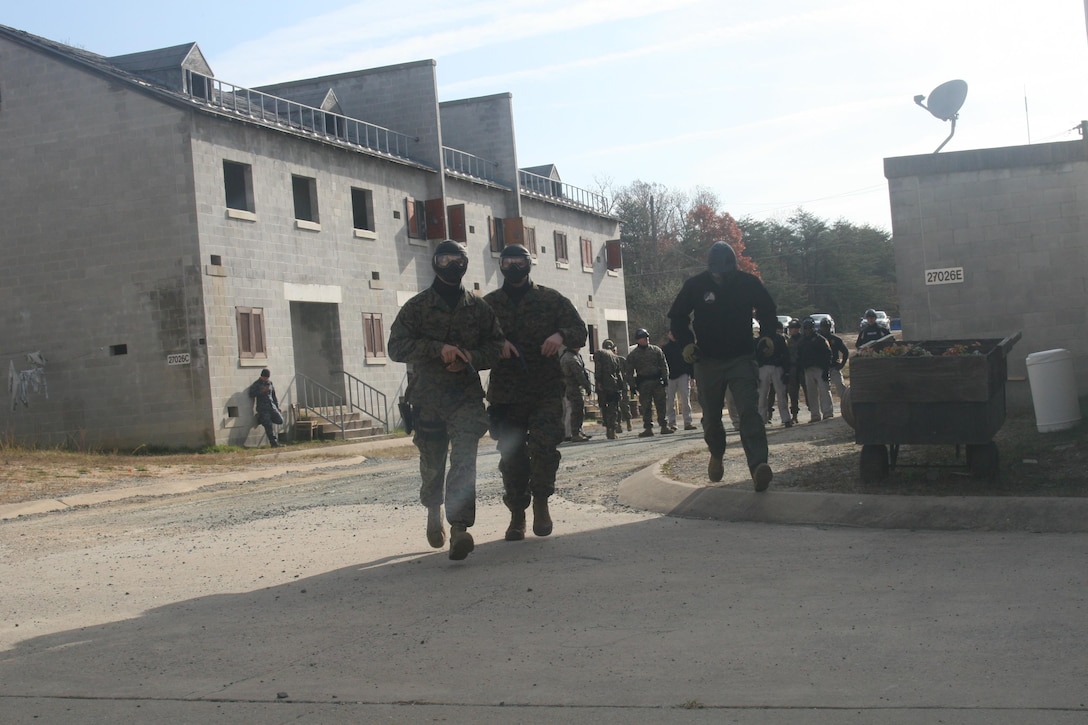 Two Marines from Security Battalion approach a building for a force-on-target training exercise aboard Marine Corps Base Quantico on Nov. 17.