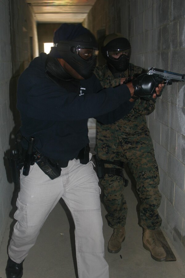 A Marine and a military police officer seek out an active trainer on the third deck of a building during a training exercise held on Nov. 17.
