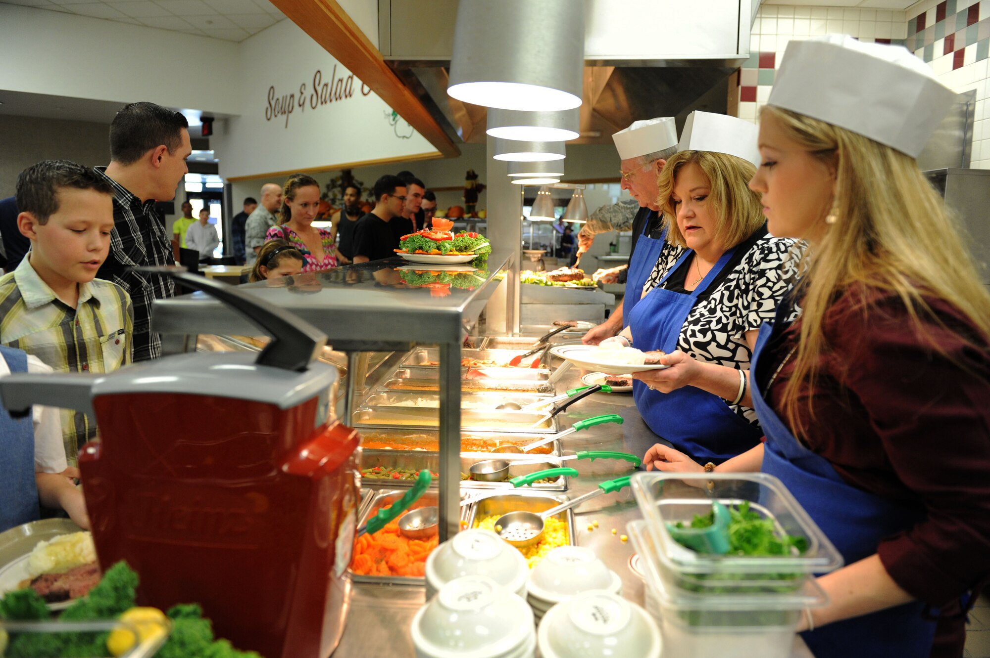Family members of Chief Master Sgt. Robert Winters, 81st Training Group superintendent, serve meals to Airmen at the Azalea Dining Facility on Thanksgiving Day, Nov. 26, 2015, Keesler Air Force Base, Miss. Keesler leadership served meals and interacted with Airmen who did not go home for the holiday. (U.S. Air Force Photo by Kemberly Groue)