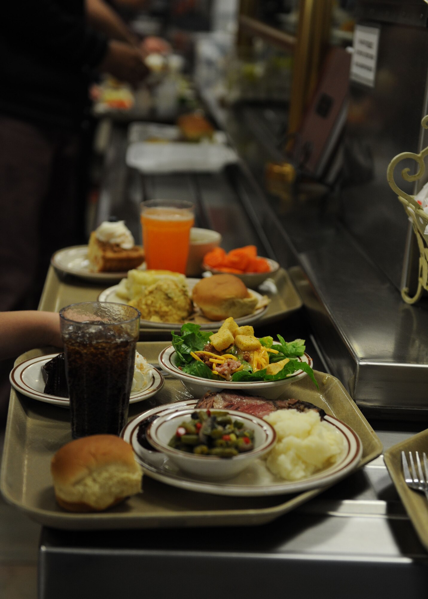 Trays of food are placed in line at the register at the Azalea Dining Facility on Thanksgiving Day, Nov. 26, 2015, Keesler Air Force Base, Miss. Keesler leadership served meals and interacted with Airmen who did not go home for the holiday. (U.S. Air Force Photo by Kemberly Groue)