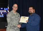 Defense Logistics Agency Aviation Commander Air Force Brig. Gen. Allan Day congratulates Christopher Farrington on being selected as DLA Aviation’s October Employee of the Month during a ceremony Nov. 25, 2015. Farrington serves as a project manager for the Industrial Plant Equipment Services Division of DLA Aviation’s Engineering Directorate in Richmond, Virginia. 