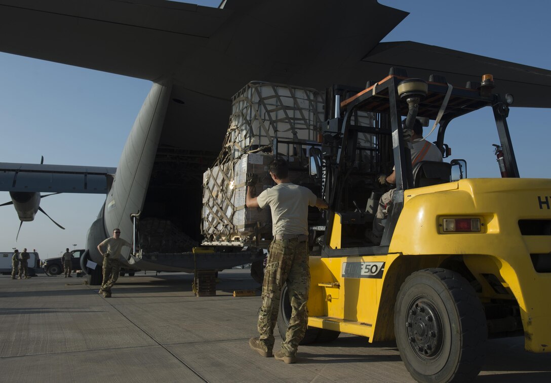 U.S. Air Force Senior Airman Zachary McGhee,left, directs a forklift behind a C-130J Super Hercules aircraft on Camp Lemonnier, Djibouti, Nov. 24, 2015. McGhee is a loadmaster assigned to the 75th Expeditionary Airlift Squadron. U.S. Air Force photo by Senior Airman Peter Thompson