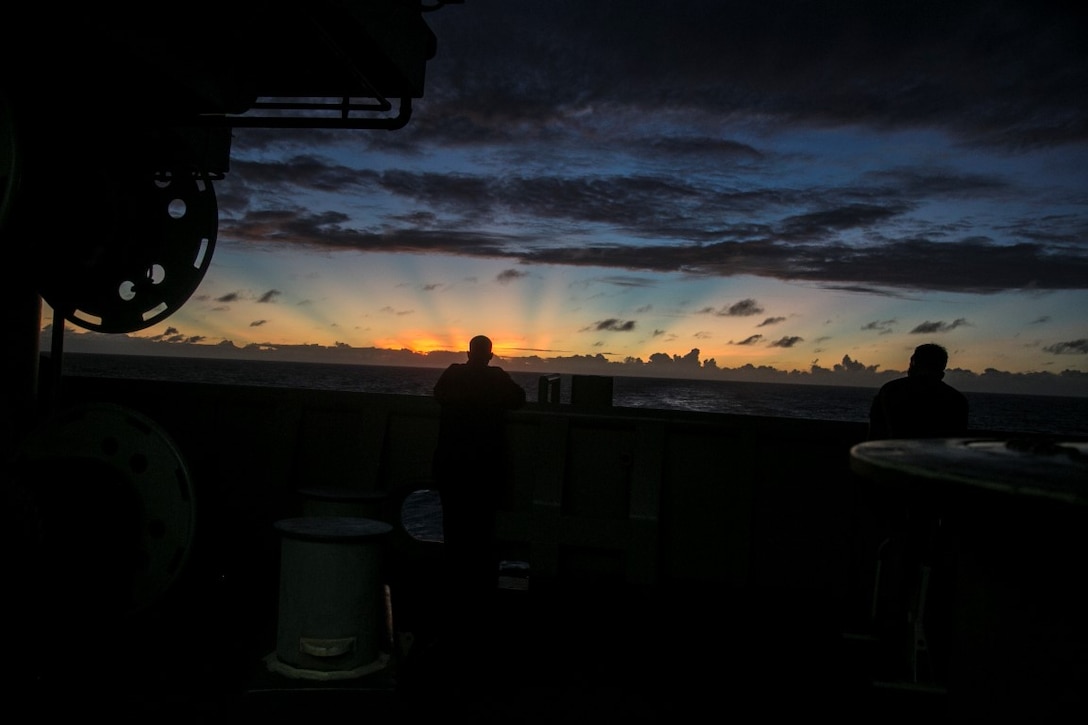 PACIFIC OCEAN (Nov. 25, 2015) U.S. Marines with the 15th Marine Expeditionary Unit watch the sun set over the horizon aboard the USS Essex (LHD 2). The 15th MEU is currently deployed in the Indo-Asia-Pacific region to promote regional stability and security in the U.S. 7th Fleet area of operations. (U.S. Marine Corps photo by Cpl. Elize McKelvey/Released)