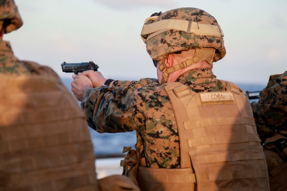 PACIFIC OCEAN (Nov. 28, 2015) U.S. Marine Gunnery Sgt. Dragos Coca fires his weapon on the flight deck aboard the USS Anchorage (LPD 23). Coca is a platoon sergeant with 1st Light Armored Reconnaissance Detachment, Battalion Landing Team 3rd Battalion, 1st Marine Regiment, 15th Marine Expeditionary Unit. The 15th MEU is currently deployed in the Indo-Asia-Pacific region to promote regional stability and security in the U.S. 7th Fleet area of operations. (U.S. Marine Corps photo by Sgt. Steve H. Lopez/Released)
