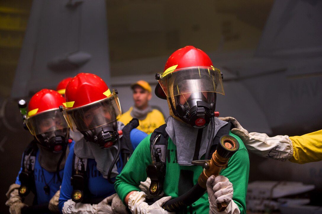 U.S. sailors fight a simulated fire during a general quarters drill in the hangar bay of the USS Harry S. Truman in the Atlantic Ocean, Nov. 28, 2015. The Harry S. Truman Carrier Strike Group is deployed to support maritime security operations and theater security cooperation efforts in the U.S. 5th Fleet and U.S. 6th Fleet areas of responsibility. U.S. Navy photo by Seaman A.O. Tinubu