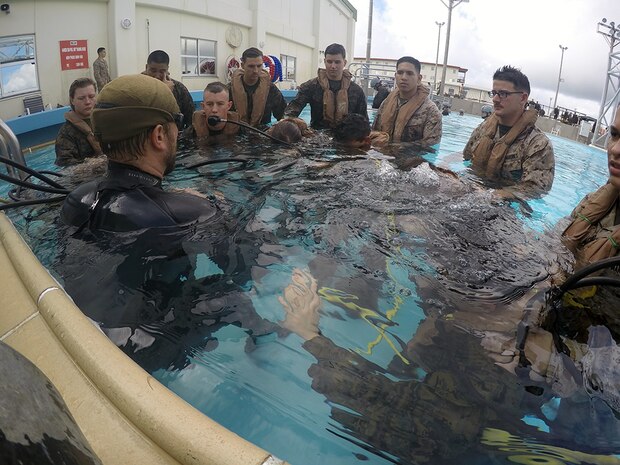 An underwater egress training instructor prepares Marines from the 31st Marine Expeditionary Unit on breathing through an emergency escape breathing device Nov. 17, 2015, on Camp Hansen, Okinawa, Japan. Marines attended the Shallow Water Egress Training Course to prepare them in the event that their vehicle were to crash in water. SWET is just one example of unique training conducted by the 31st MEU Marines. 