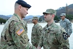 Brig. Gen. Brian J. Mennes, deputy commanding general-maneuver, 2nd Infantry Division/U.S.-ROK Combined Division, congratulates 1st Lt. Jeffrey Soboleski, a Baltimore, Md., native and physician assistant from Headquarters and Headquarters Battery, 6th Battalion, 37th Field Artillery Regiment, 210th Field Artillery Brigade, 2nd Infantry Division/ ROK-U.S. Combined Division, with an Army Achievement Medal during the Expert Field Medical Badge graduation ceremony Nov. 24 at Camp Casey, South Korea. Soboleski was recognized as one of the course's honor graduate after earning the highest written test score with a 93 percent.