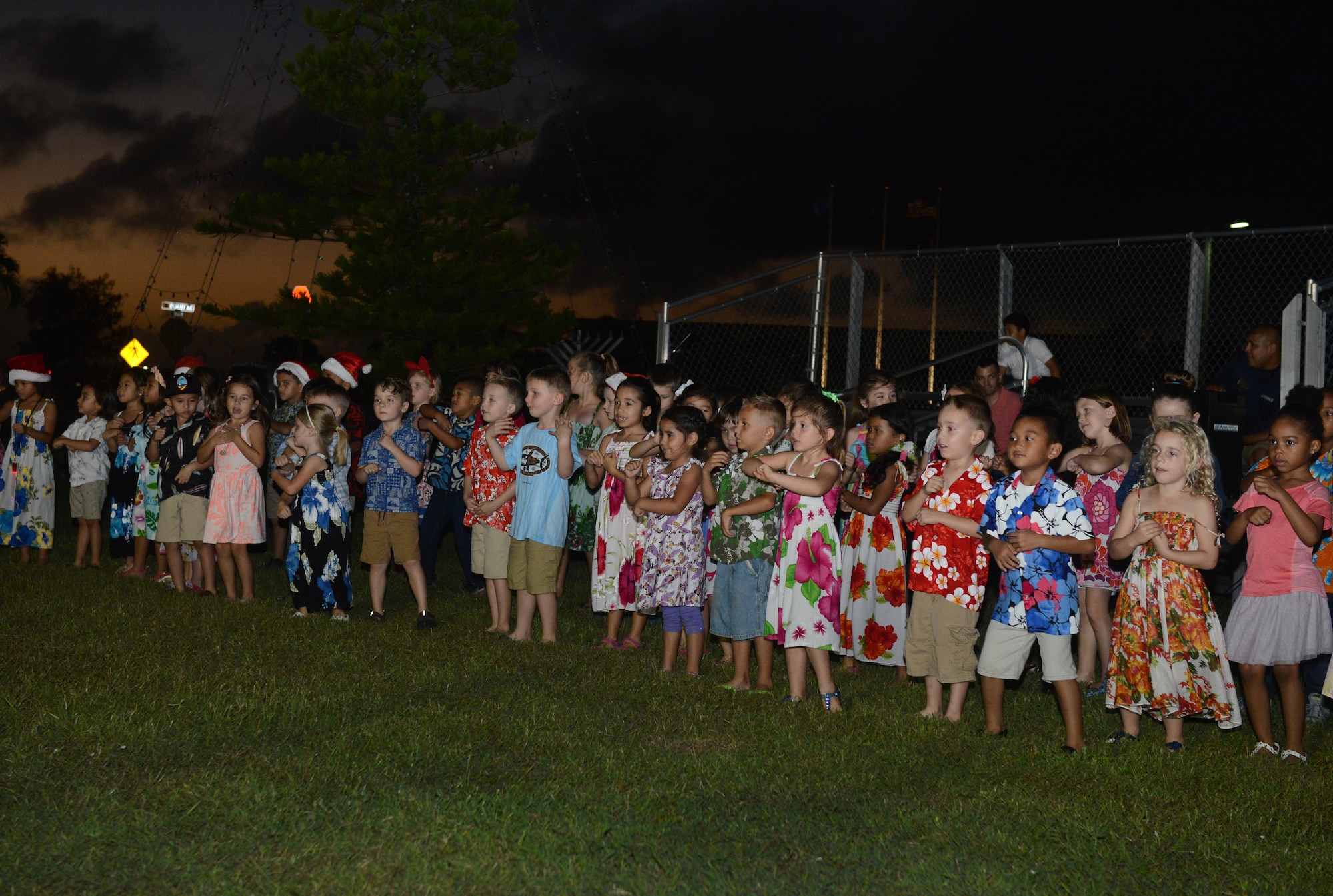 Andersen Elementary School children sing holiday songs at the tree lighting ceremony Dec. 1, 2015, at Andersen Air Force Base, Guam. Approximately 300 people attended the ceremony in celebration of the holiday season. (U.S. Air Force photo by Airman 1st Class Arielle Vasquez/Released)