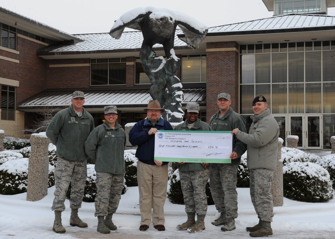 Kevin Ott, center, Air Force Sergeants Association Chapter 951 special event coordinator, poses with members of base private organizations in conclusion of the annual Combined Federal Campaign at Ellsworth Air Force Base, S.D., Nov. 30, 2015. More than 10 base organizations donated more than $9,000 to two CFC charities, the Gary Sinise Foundation & Intrepid Fallen Heroes Fund. The CFC is designed to provide servicemembers and Department of Defense civilians an opportunity to contribute to their choice of approved local and national charities during a designated period of time. (U.S. Air Force photo by Airman 1st Class Denise M. Nevins/Released)