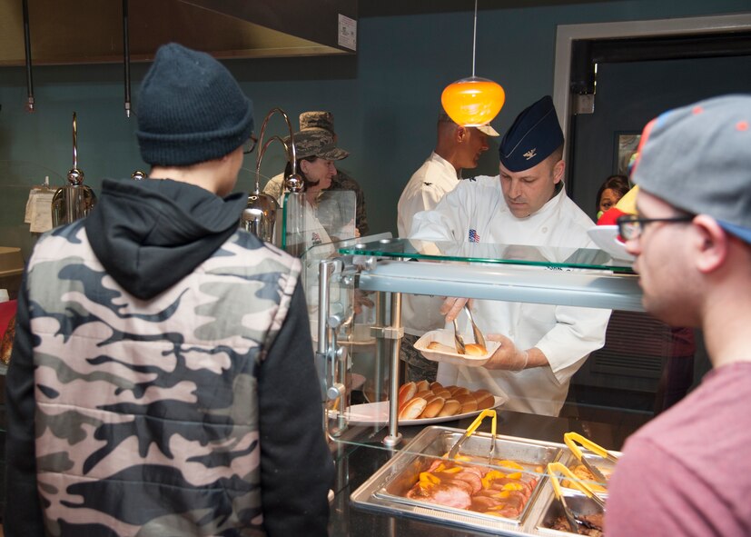 Col. William Hall, 436th Operations Group commander, serves bread to Airmen during Thanksgiving at the Patterson Dining Facility Nov. 26, 2015, on Dover Air Force Base, Del. The fest included the standard Thanksgiving foods; hand carved turkey and ham, yams, stuffing, and more. (U.S. Air Force photo/Staff Sgt. Jared Duhon)