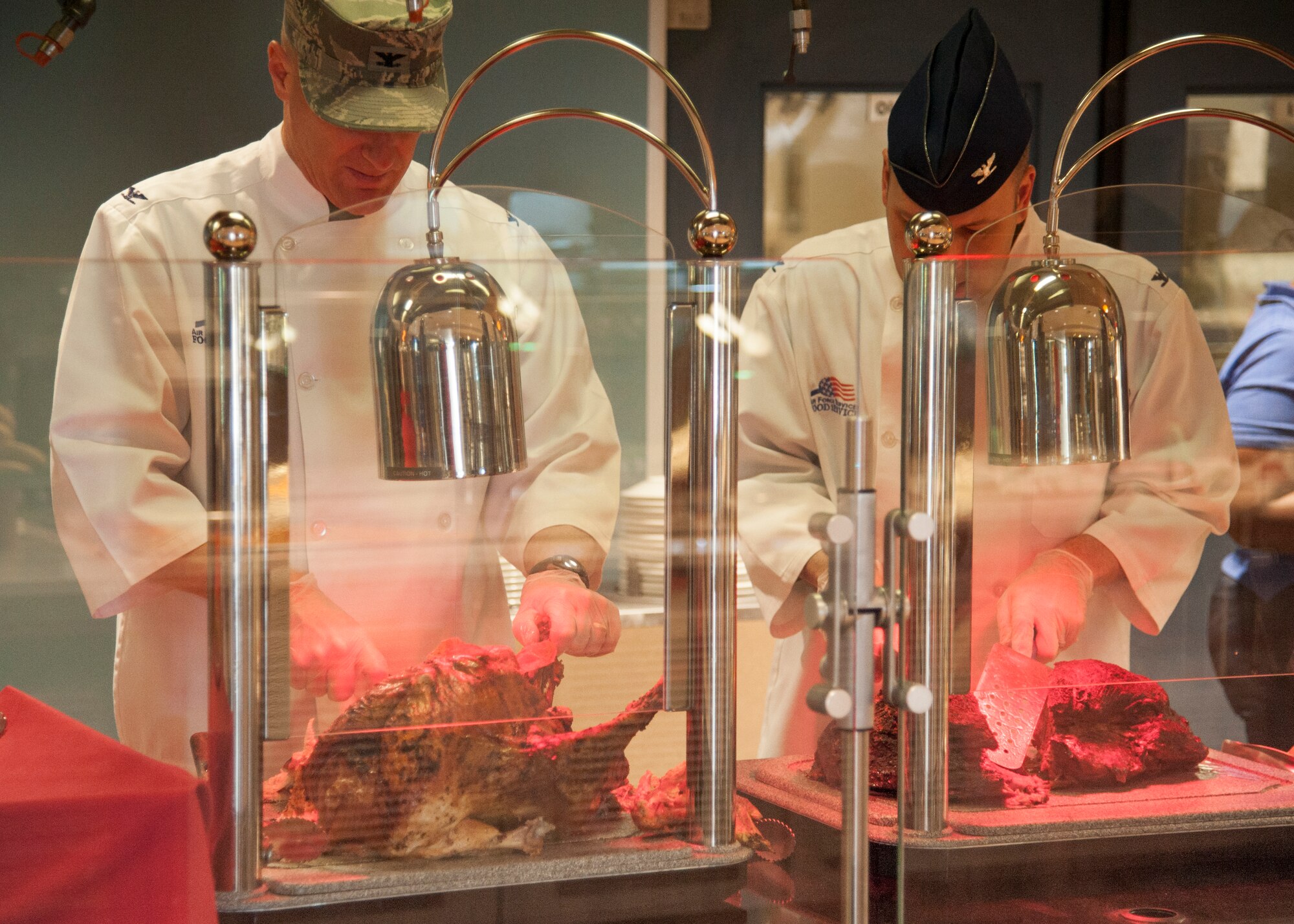 Col. Michael Grismer, 436th Airlift Wing commander, and  Col. William Hall, 436th Operations Group commander, carve meats for Thanksgiving at the Patterson Dining Facility Nov. 26, 2015, on Dover Air Force Base, Del. The meal was open to all Airmen and anyone with access to the base. (U.S. Air Force photo/Staff Sgt. Jared Duhon)