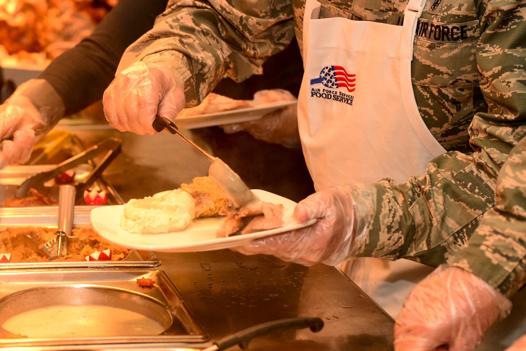 Langley leadership joined together to serve U.S. Service members, retirees and families a Thanksgiving meal at Langley Air Force Base, Va., Nov. 26, 2015. Leadership served ham, turkey and mashed potatoes with gravy, among other staples, to those who could not go home during the holiday. (U.S. Air Force photo by Airman 1st Class Derek Seifert)